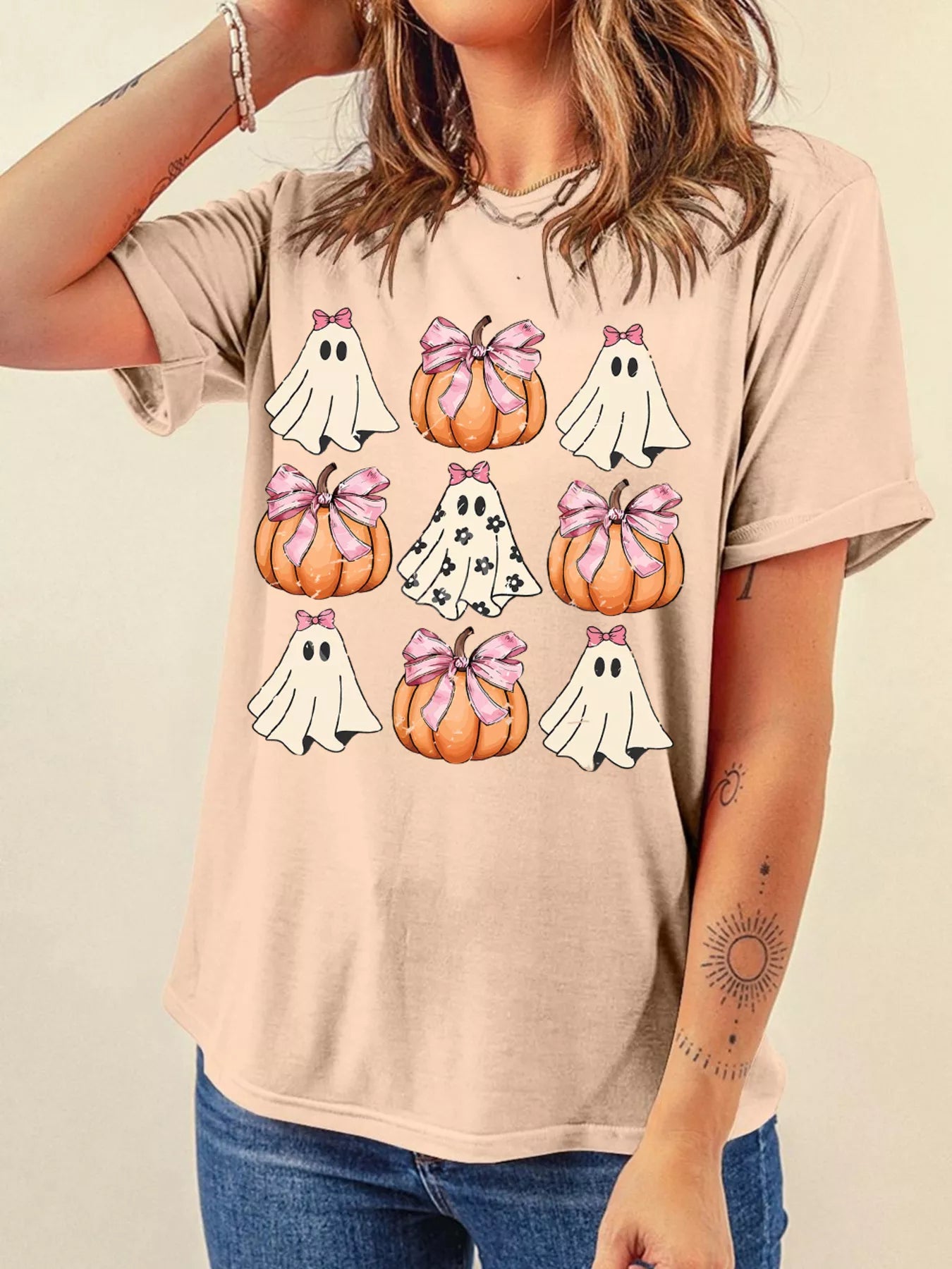 Women's Halloween graphic t-shirt featuring cute ghosts and pumpkins with bows, perfect for spooky season.