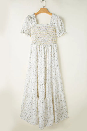 Floral smocked short puff sleeve maxi dress on hanger, feminine design with tiered skirt and floral patterns.