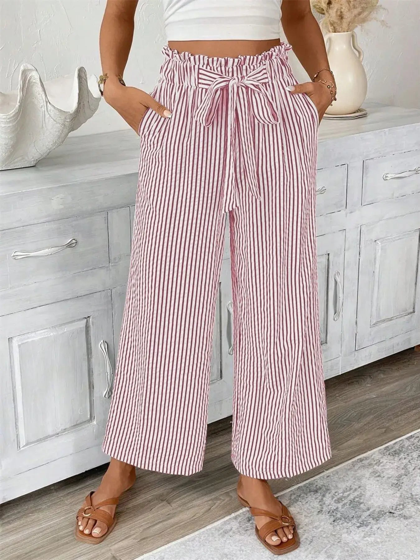 Full size striped wide leg paper bag pants in red and white, featuring pockets and tie detail.