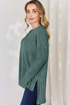 Model wearing a ribbed high-low long sleeve t-shirt in teal, showcasing side view and relaxed style.