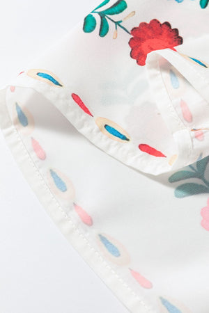 Close-up of floral print fabric featuring red and blue flowers on a sheer blouse.