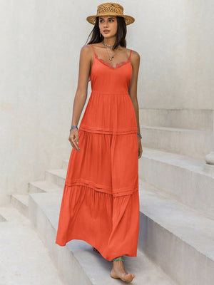 Model wearing a coral lace detail V-neck cami dress with a straw hat, standing on outdoor steps.