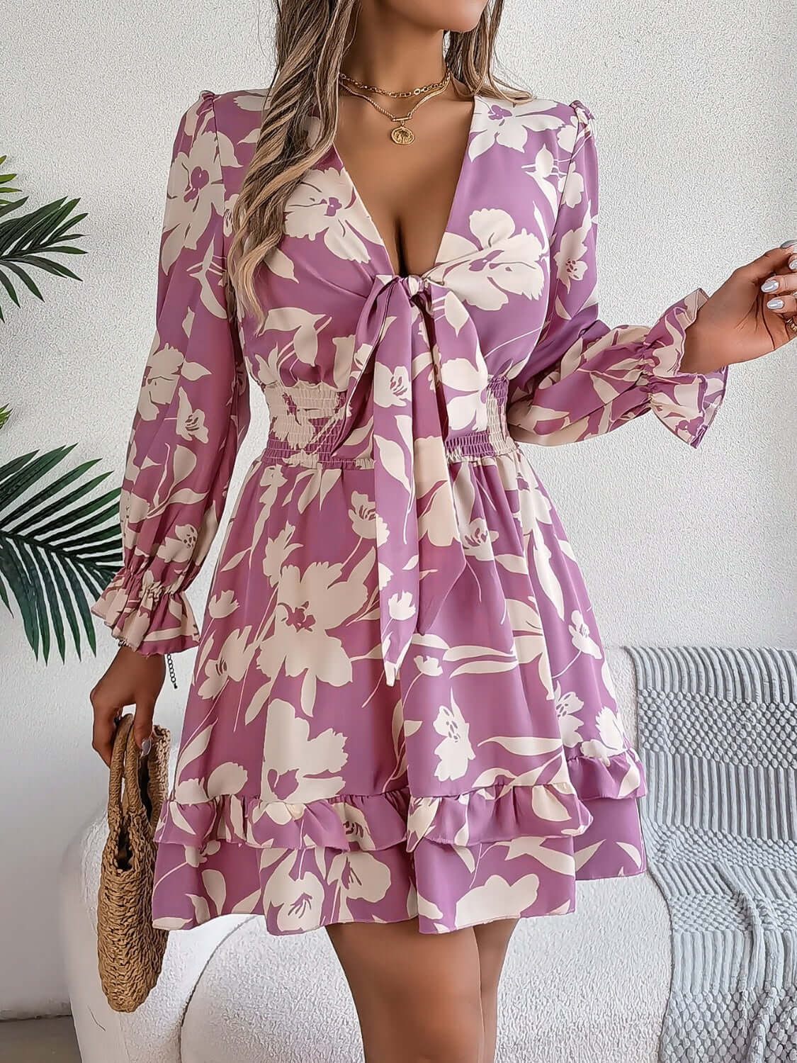 Tied ruffled long sleeve dress in floral print, featuring a flattering silhouette and soft pink hues.