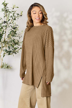 Model wearing a basic ribbed long sleeve top with side slit, paired with beige pants, against a soft background.
