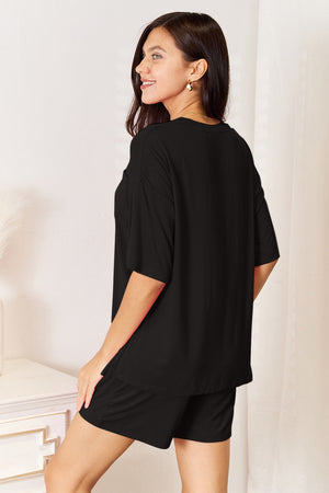 Woman showcasing a black half-sleeve top and shorts set, perfect for lounging or casual outings.