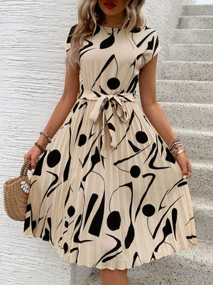 Tied pleated cap sleeve dress with abstract black and beige print, perfect for casual summer outings.