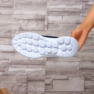 Lightweight breathable mesh slip-on shoe sole showing textured rubber for grip on a stone background.