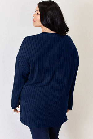 Back view of a plus-size model in a navy ribbed oversized sweater, showcasing its relaxed fit and stylish design.