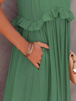 Woman's hand in pocket of ruffled sleeveless tiered maxi dress in green, showcasing stylish detail and comfort.