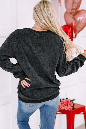 Back view of a woman wearing a Heart Round Neck Dropped Shoulder Sweatshirt in dark color with long sleeves.