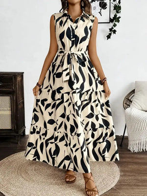 Printed tie waist sleeveless maxi dress featuring floral design, buttoned front, and tiered skirt.