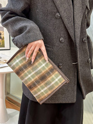 Contrast plaid clutch with zipper, featuring a stylish design, held in hand, perfect for small essentials.