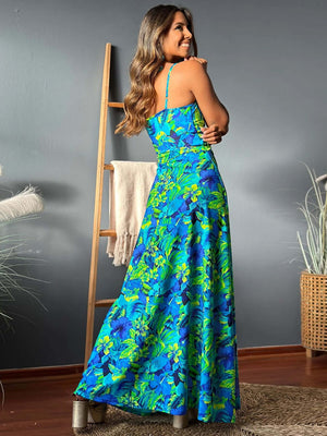 Back view of a woman modeling a vibrant twisted printed v-neck cami dress with blue and green floral design.