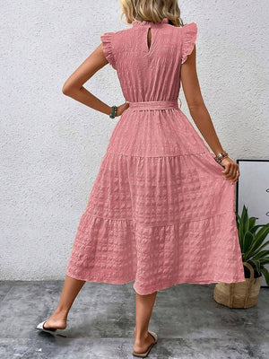 Back view of a tied ruffled cap sleeve midi dress in pink, featuring a tiered design and keyhole detail.