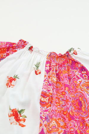 Colorful printed V-neck short sleeve blouse featuring floral design and silky texture, perfect for warm weather.