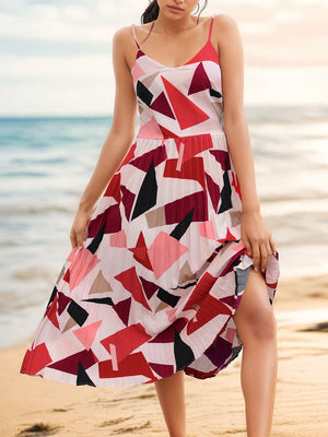 Pleated geometric spaghetti strap dress in red and pink geometric patterns, perfect for beach outings.