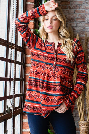 Model wearing a vibrant geometric button detail long sleeve babydoll top in a stylish setting.