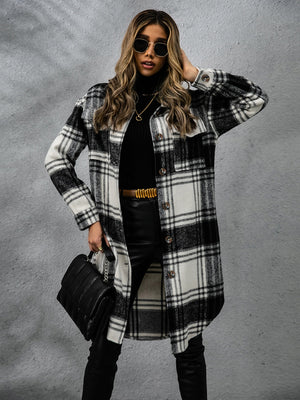 Chic woman in plaid collared long sleeve coat, stylishly paired with black top and sunglasses.