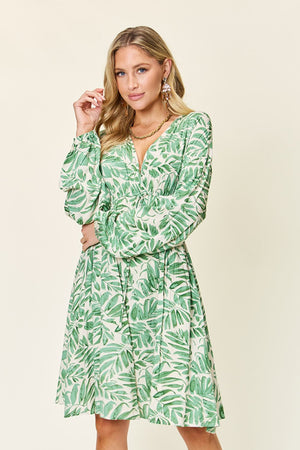 Model wearing a green leafy print ruched balloon sleeve dress, showcasing the stylish design and nature-inspired pattern.