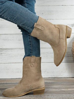 Western style block heel boots in beige suede, paired with skinny jeans, showcasing low heel comfort and chic design.