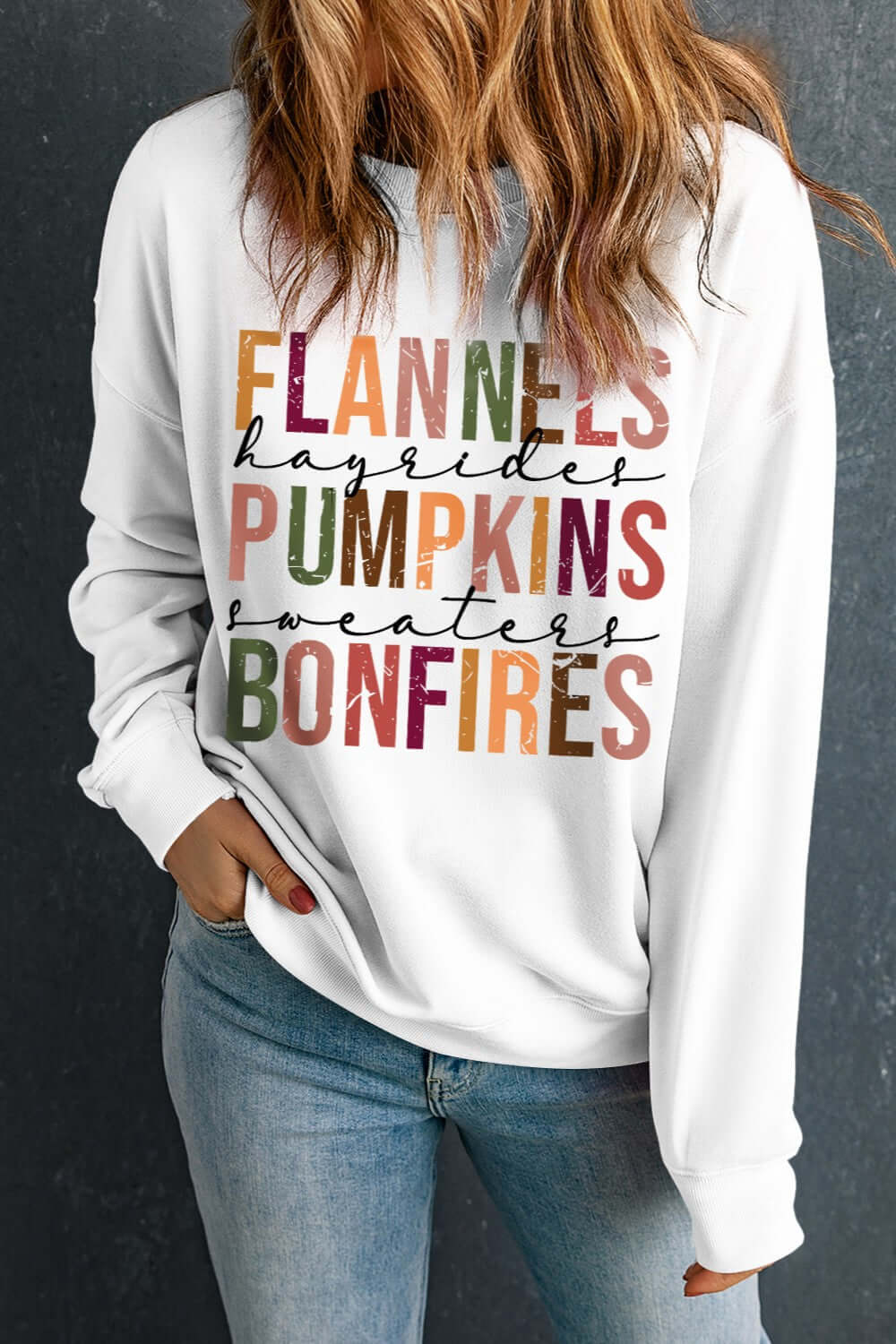 Women's white long sleeve sweatshirt with fall-themed text: flannels, hayrides, pumpkins, sweaters, bonfires.
