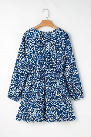 Blue printed tie neck long sleeve dress with elastic waistband and ruffled hem, perfect for casual outings.