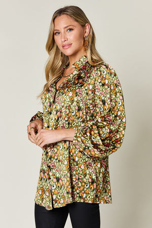 Model wearing a Double Take full size printed long sleeve blouse with a vibrant floral pattern and puff sleeves.