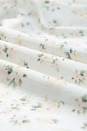 Close-up of soft fabric with a delicate floral print in pastel colors, perfect for a floral dress.