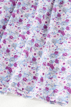 Close-up of the tiered floral fabric featuring purple and blue flowers on a soft background for a maxi dress.