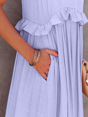 Close-up of ruffled sleeveless maxi dress in soft blue, featuring pockets and stylish details for a chic summer look.