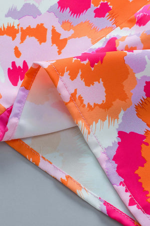 Close-up of vibrant printed fabric showcasing pink, orange, and purple patterns for a V-neck blouse.