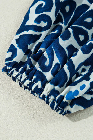 Close-up of gathered sleeve detail in blue and white printed fabric for a tie neck long sleeve dress.