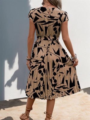 Back view of a tied pleated printed cap sleeve dress with black abstract patterns on a beige background.