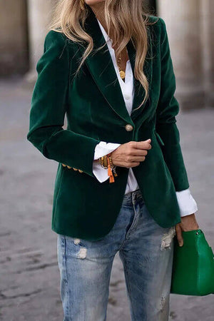 Stylish woman wearing a green lapel collar one button blazer, paired with a white shirt and distressed jeans.