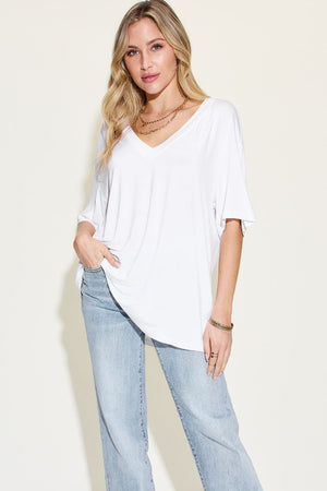 Model wearing Basic Bae Full Size Bamboo V-Neck Drop Shoulder T-Shirt in white with light wash jeans.