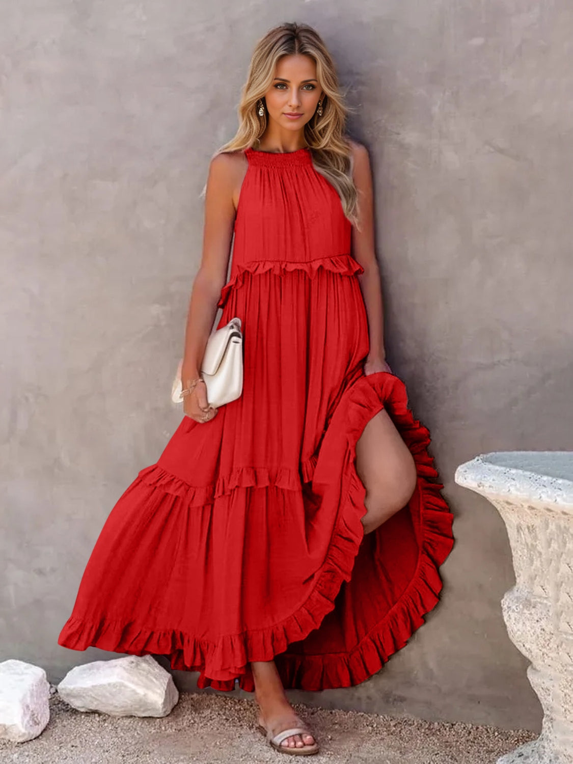 Model wearing a ruffled sleeveless tiered maxi dress in red with pockets, styled with a handbag and sandals.