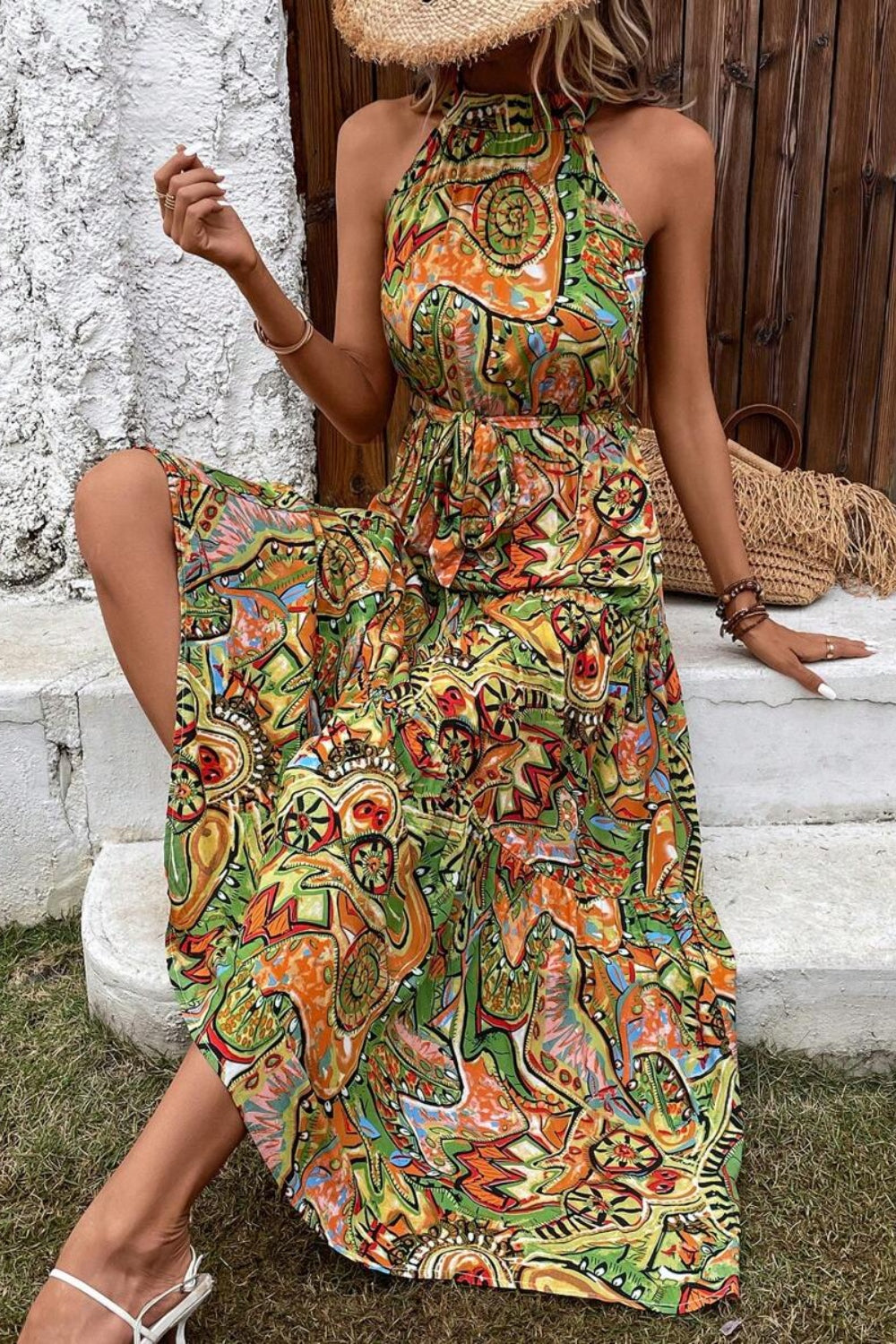 Model in a vibrant Tied Slit Floral Sleeveless Dress, showcasing earthy tones and a flowy design, perfect for summer outings.
