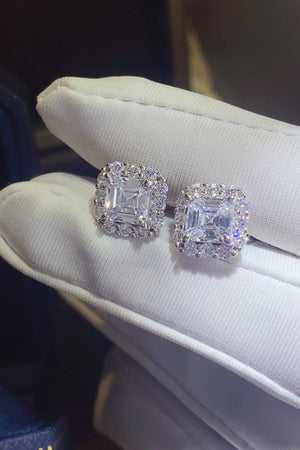 Elegant 2 carat Moissanite stud earrings set in platinum-plated 925 sterling silver, displayed on plush white fabric.