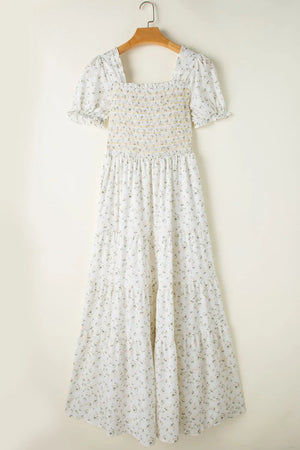 Floral smocked short puff sleeve maxi dress on a hanger, featuring a tiered design and a square neckline.