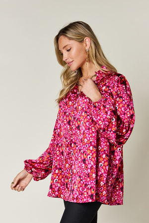 Model wearing a vibrant pink printed long sleeve blouse with frills, ideal for stylish casual looks.