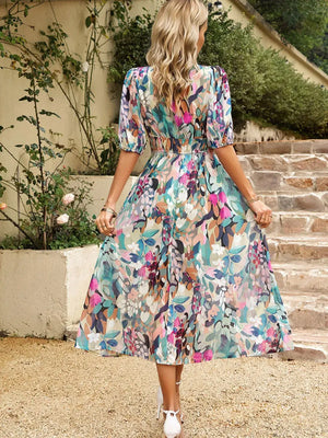 Back view of a floral printed puff sleeve midi dress, showcasing vibrant colors and a flowing design.