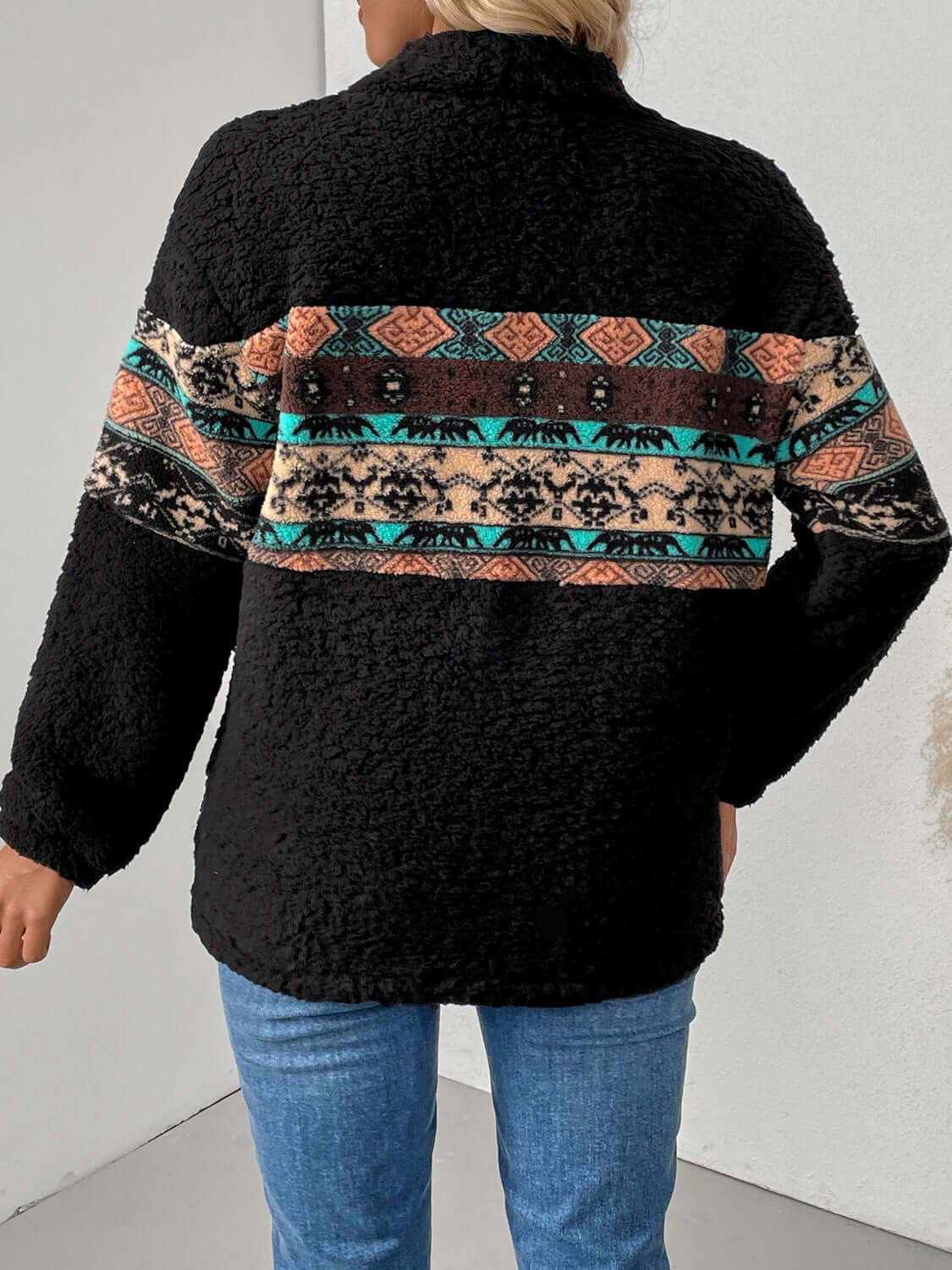 Back view of a cozy black fleece sweatshirt with multicolor geometric stripes.
