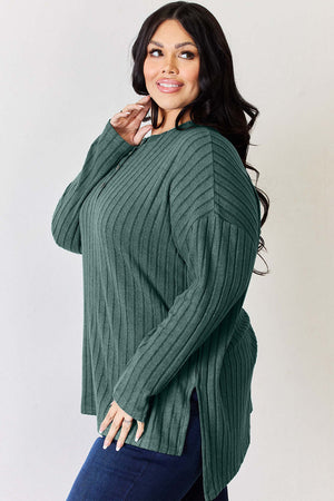 Model in high-low ribbed long sleeve T-shirt showcasing side slit in green, perfect for casual style.