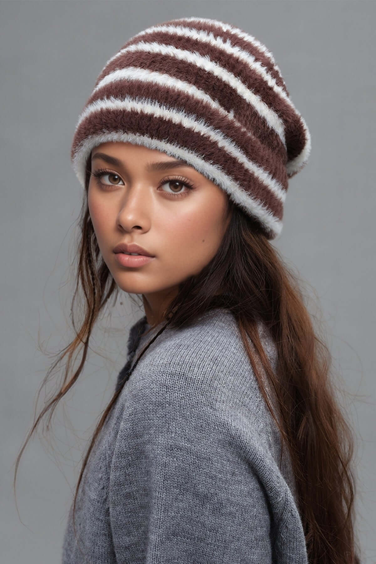 Fuzzy contrast striped thermal hat in brown and white worn by model. Soft nylon material for warmth and style.