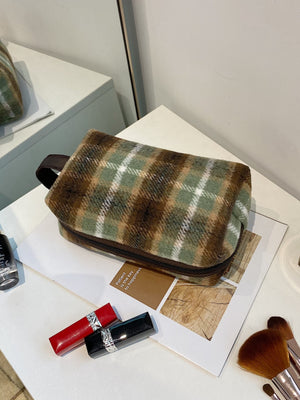 Contrast plaid clutch bag with zipper, showing a stylish design in green and brown, perfect for small essentials.
