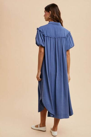 Model wearing a blue mineral washed button down puff sleeve shirt dress, showcasing the back view and chic design.