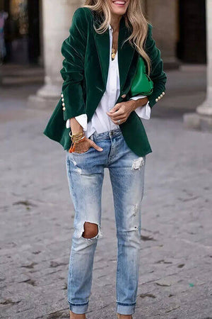 Stylish woman in green lapel collar blazer with ripped jeans, showcasing a chic and modern look.