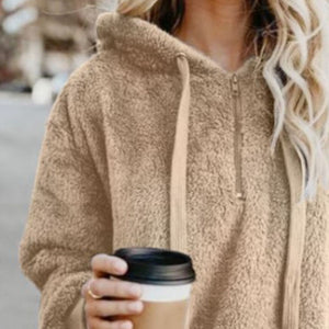 Woman holding coffee in a tan quarter-zip drawstring teddy hoodie, perfect for cozy casual wear.