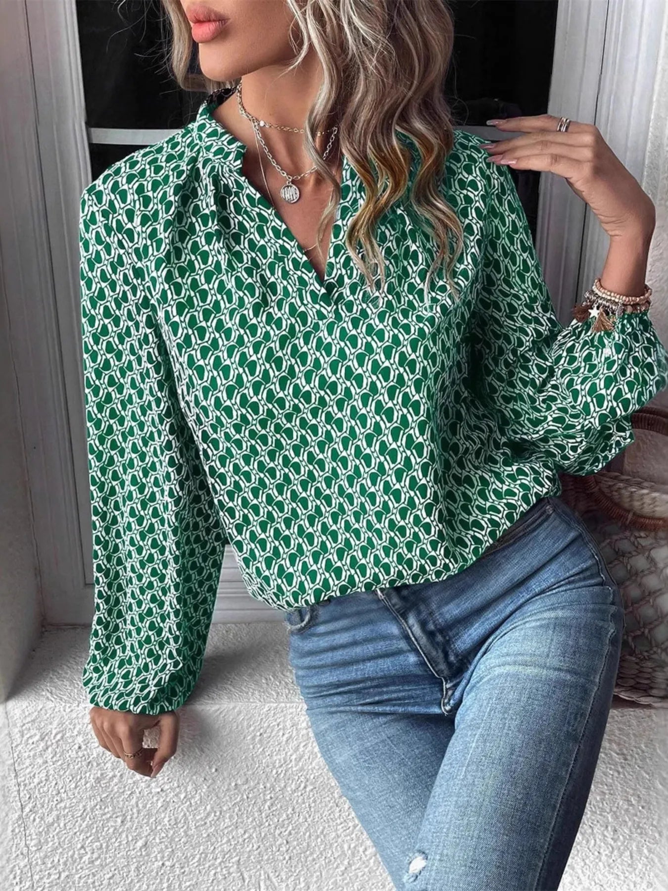 Stylish green printed notched long sleeve blouse, worn with blue jeans, perfect for casual wear.