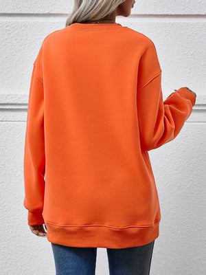 Back view of a woman wearing an orange round neck sweatshirt, showcasing its relaxed fit and cozy style.